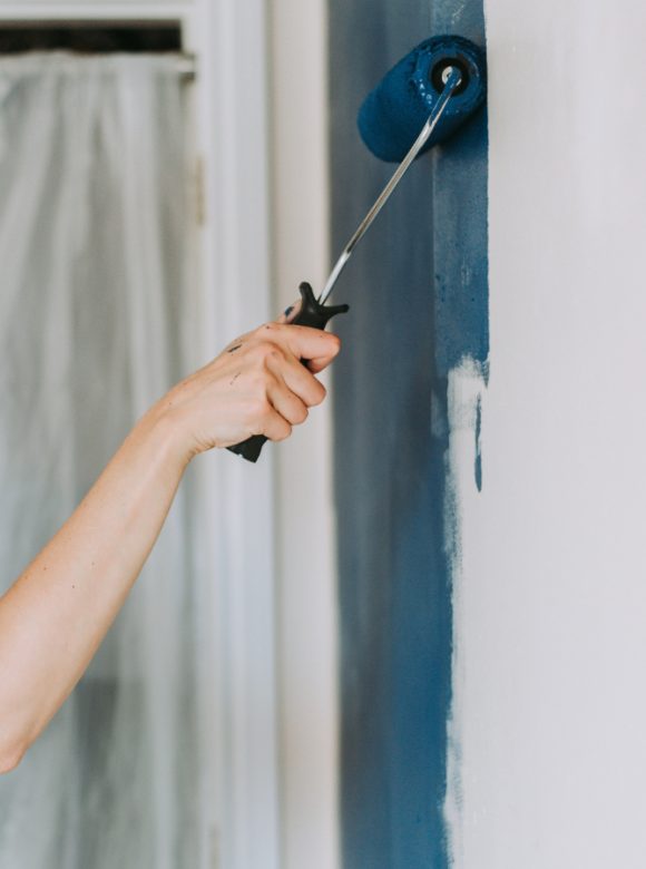 closeup-shot-person-using-paint-rollers-with-color-blue